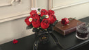 Stilvolle Videopräsentation des Robotime Red Rose Bouquet, Kunststoff-Bausatz für einen Strauß roter Rosen und weißer Gänseblümchen in einer schwarzen Vase mit schwarzem Band darum