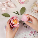 Eine Person baut die Robotime Pink Camellia