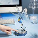 Eine Person bedient den Touch-Knopf des Robotime Butterfly (Blue), um die Flügel zu bewegen