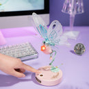 Eine Person benutzt den Touch-Knopf, um die Flügel des Robotime Butterfly (Pink) zu bewegen