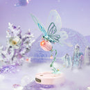 Atmosphärische Präsentation der Robotime Butterfly (Pink), Elektrischer Bausatz eines hellblauen Schmetterlings, der mit seinen Flügeln flattern kann, auf einer rosa Blume