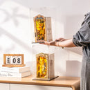 Eine Person stapelt zwei Book Nooks in Robotime Dust Covers WD1001