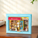 Atmosphärische Präsentation der Robotime Fluffy Cat Bakery, Diorama in einem Rahmen, das eine Bäckerei mit einer Katze zeigt