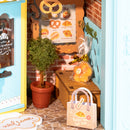 Verpacktes Kuchen, eine Pflanze, Tasche und Schild mit Speisekarte in der Robotime Fluffy Cat Bakery