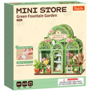 Vorderseite der Verpackung der Robotime Green Fountain Garden, Bausatz für ein Miniaturhaus eines Blumenladens in einem eleganten Gewächshaus