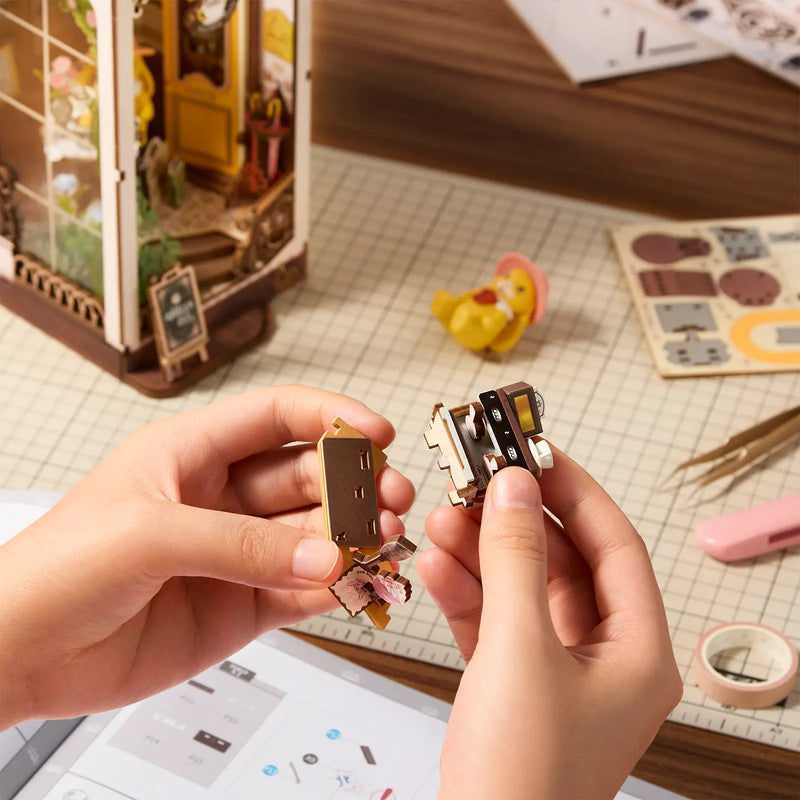 Eine Person baut einen Teil der Bar des Robotime Holiday Café zusammen