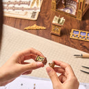 Eine Person baut einen Teil der Robotime Library of Wonders zusammen