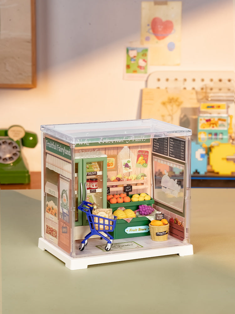 Atmosphärische Präsentation der Robotime Nature Energy Fruits, Miniatur-Obstladen aus Kunststoff in einer kleinen Vitrine