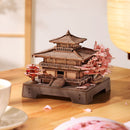 Atmosphärische Präsentation der Robotime Sakura Pavilion, Holzbausatz für einen japanischen Pavillon mit Kirschblüten an den Seiten des Gebäudes