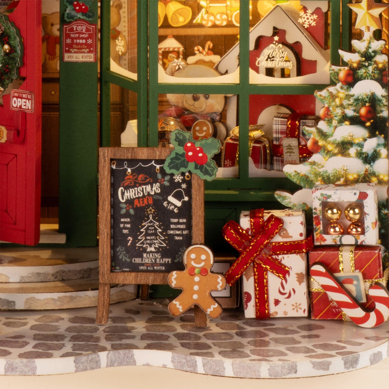 Nahaufnahme des Schaufensters, Weihnachtsbaum mit Geschenken und Ladenschild des Robotime Santa’s Toy Shop