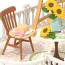 Nahaufnahme der Vase mit Sonnenblumenund des Stuhls mit Strohhut von der Robotime Sunny Break Terrace