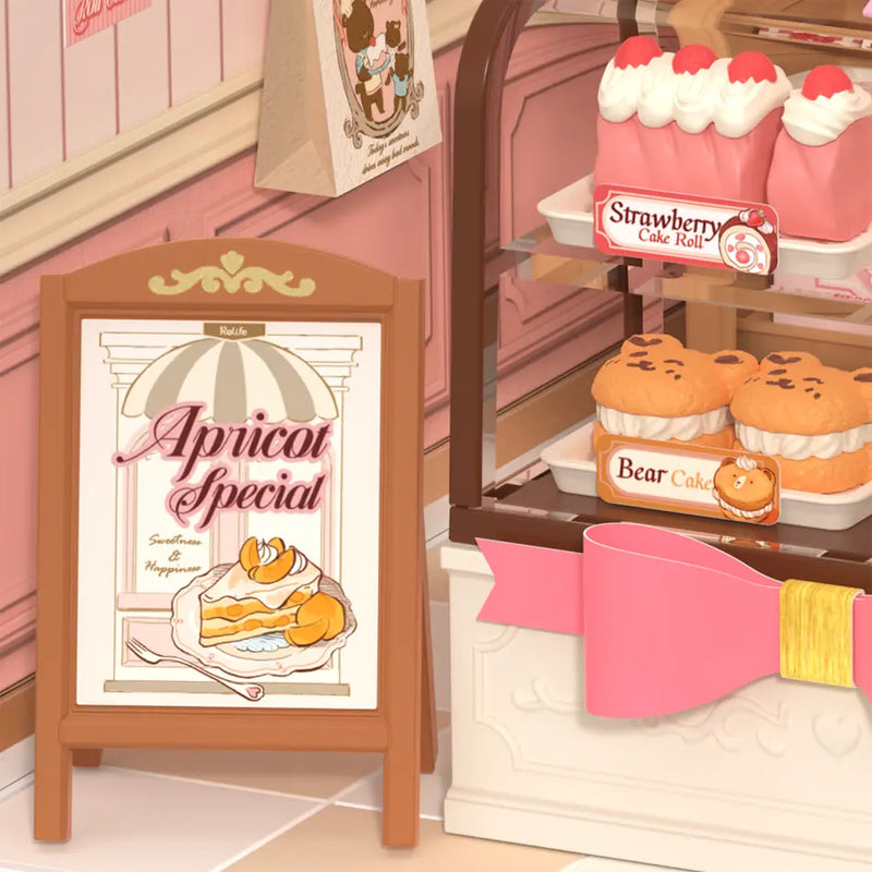 Nahaufnahme des Ladenschilds und des Gebäcks im Schaufenster des Robotime Tasty Cake Shop