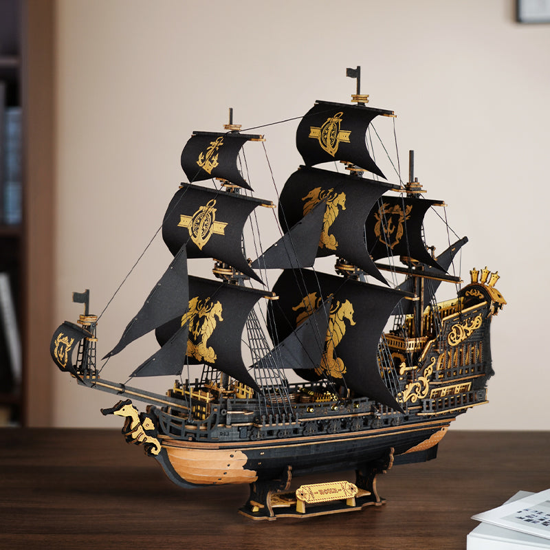 Atmosphärische Präsentation der Robotime Seahorse Barque, schwarzes Segelschiff aus Holz mit goldenen Details