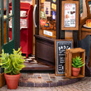 Pflanzen und Schilder vor der Tür der Robotime Tipsy Restaurant