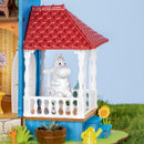 Moomintroll sitzt draußen auf der Veranda des Rolife Moominhouse